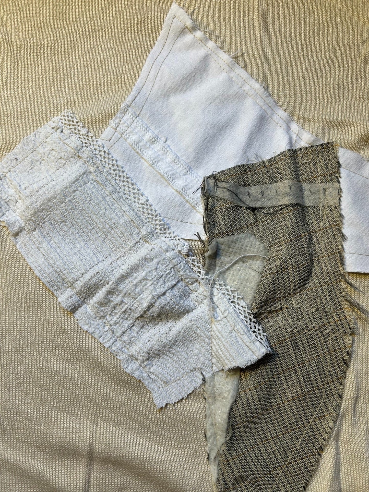 Thoughts Reworked beige knit sweater with mixed media appliques of white cotton, grey tweed, and lace trim.