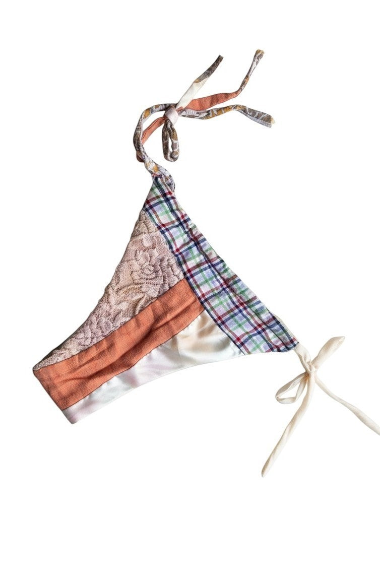 Thoughts Reworked upcycled patchwork bikini top with lace trim, featuring plaid, orange, and satin panels with tie closures.
