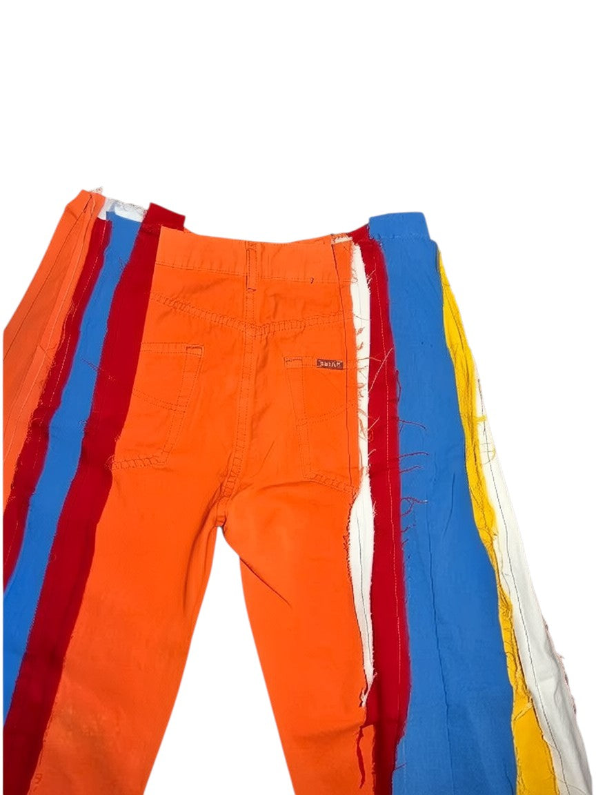 Thoughts Reworked patchwork wide leg jeans in orange, red, blue, yellow, and white denim. Deconstructed, upcycled design.